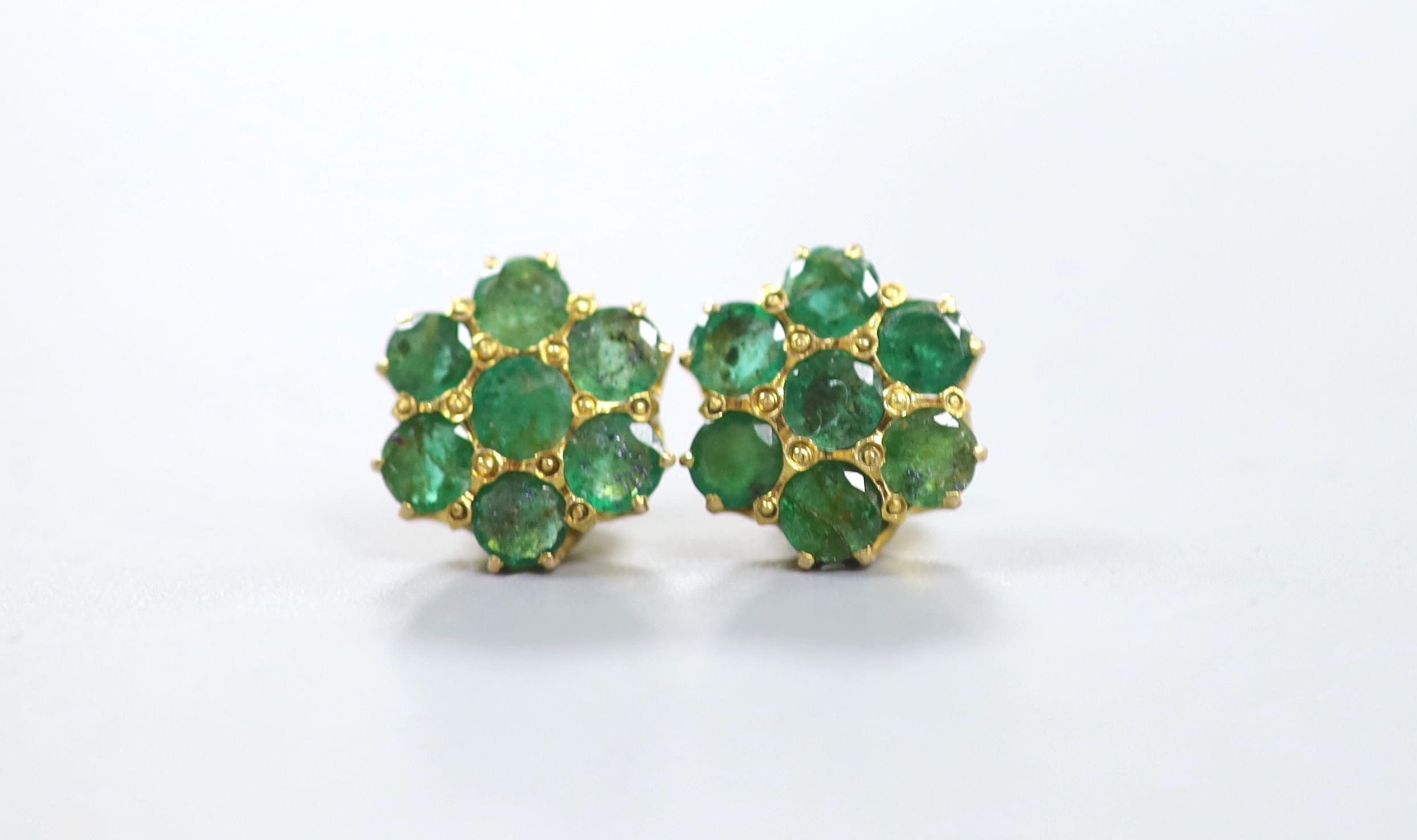 A pair of yellow metal and emerald flower head cluster set earrings, 12mm, gross 4.9 grams.